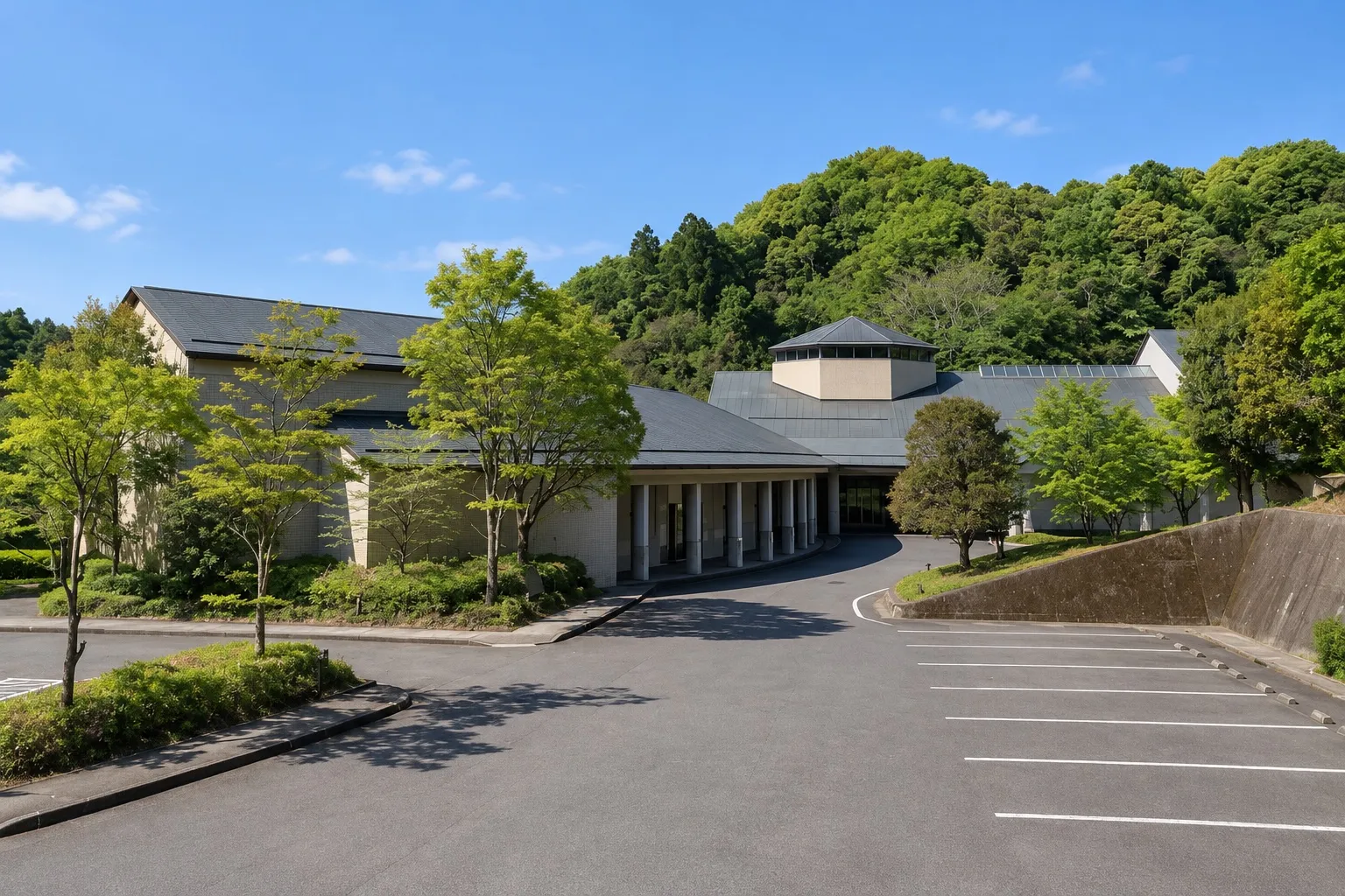 長南聖苑の外観。緑の山を背にした低い建物と車寄せ(イメージ)